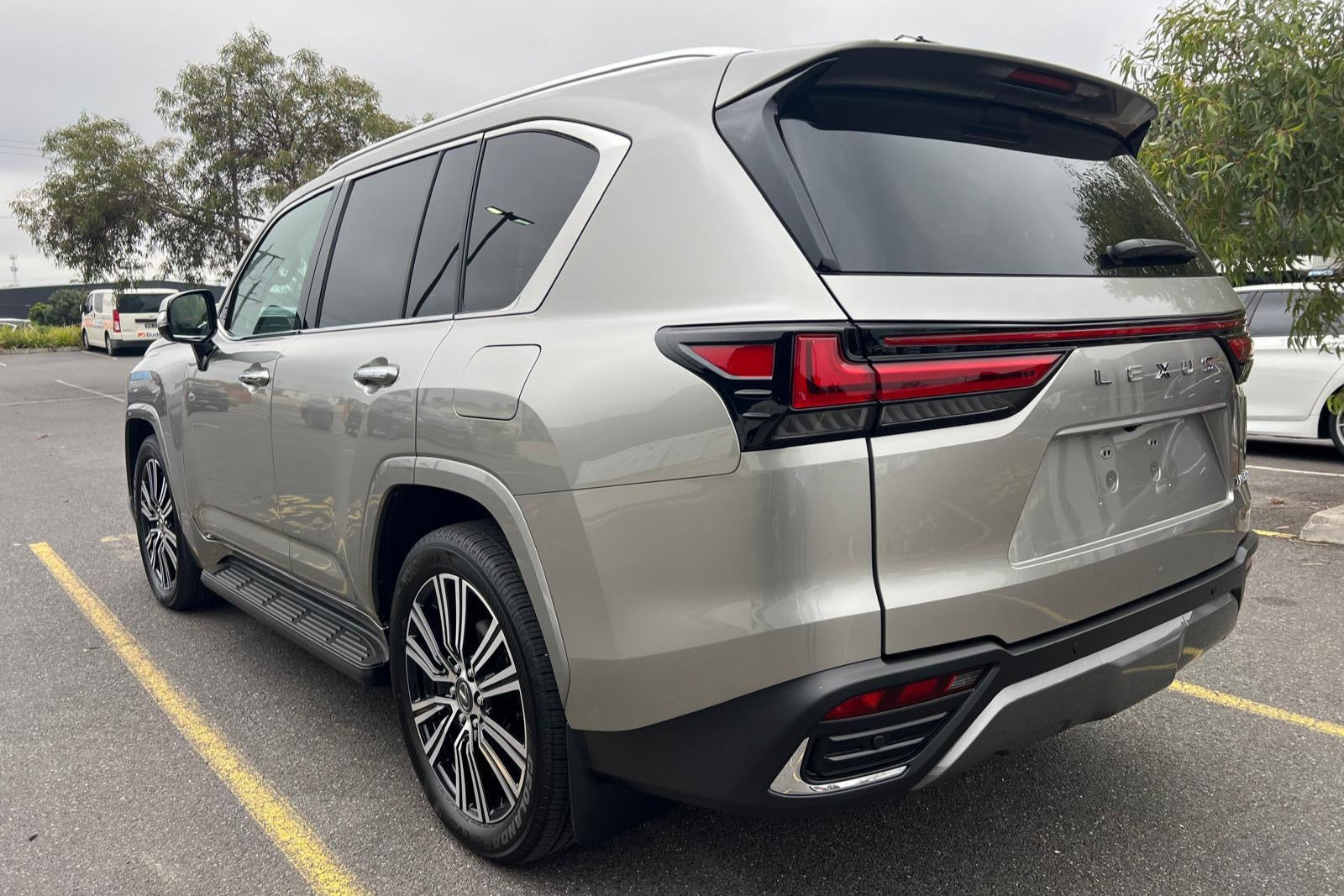 Silver SUV parked on a road with trees in the background