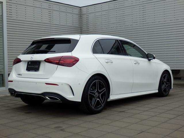 White Mercedes-Benz car parked in front of a gray building