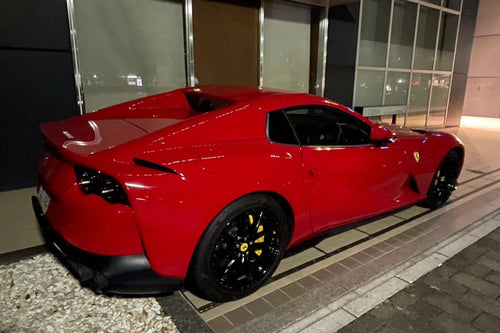 Red sports car parked on a street at night