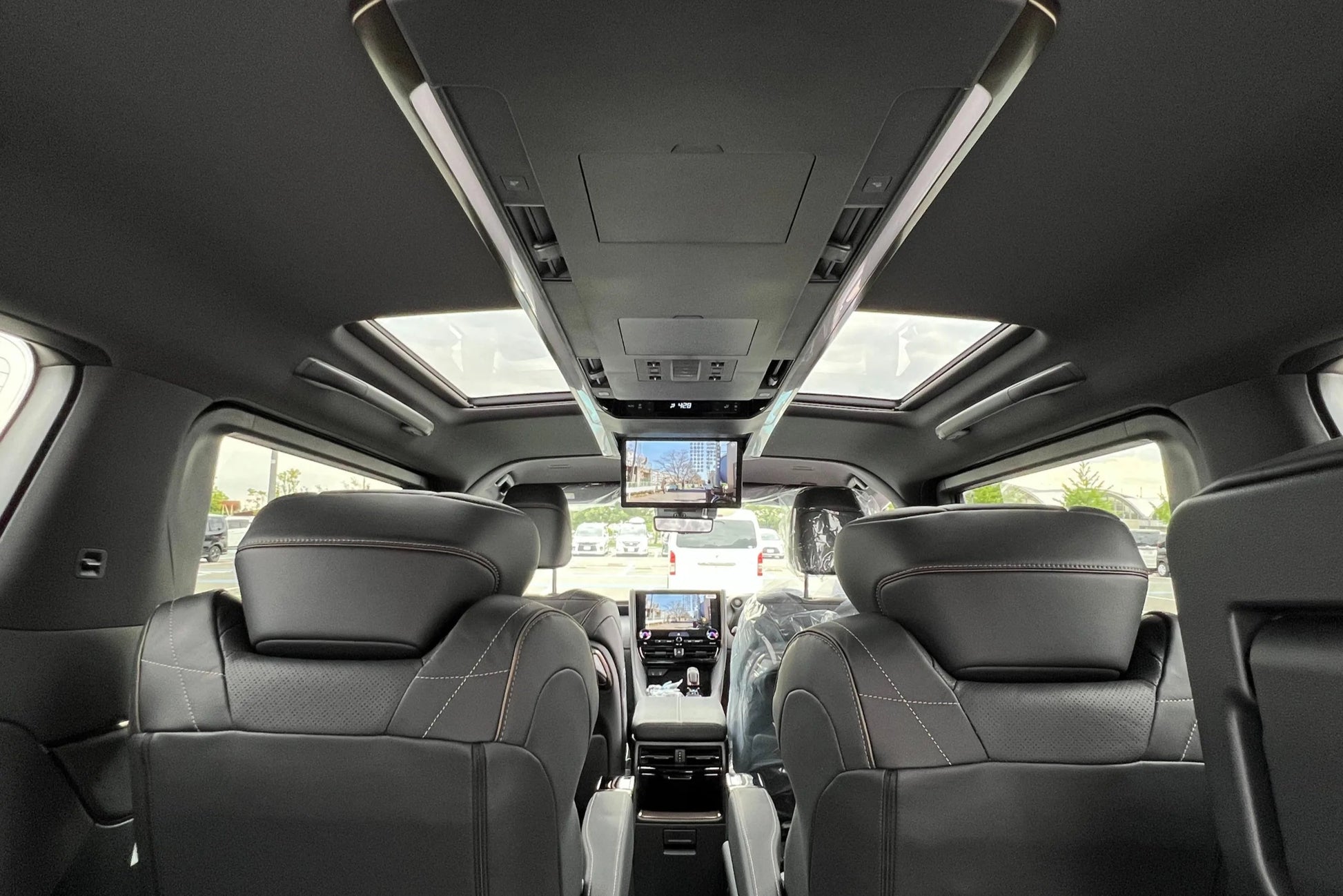 Interior of a vehicle with gray seats and a sunroof.