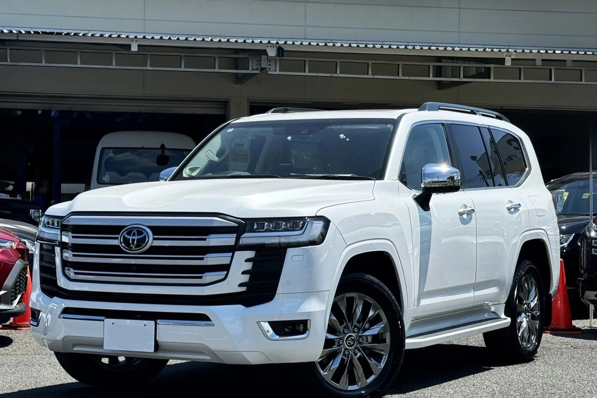 White Toyota SUV parked in a lot with a building in the background