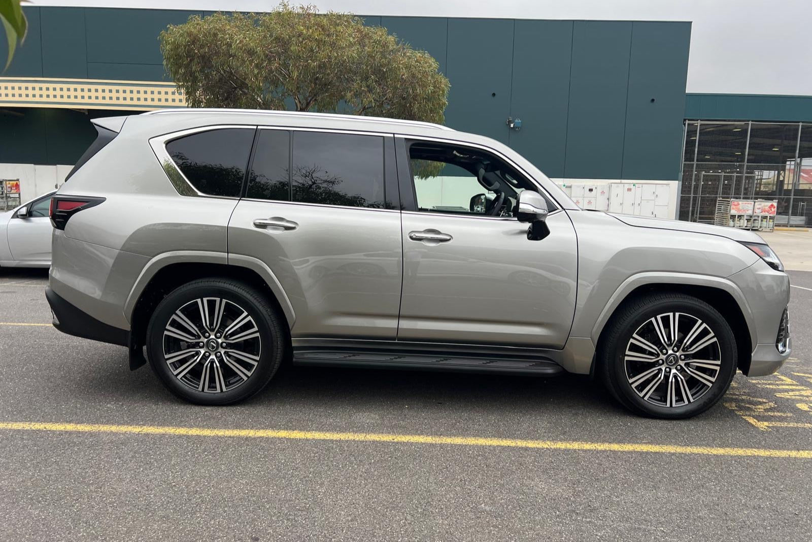 White SUV parked on a paved surface with a building in the background